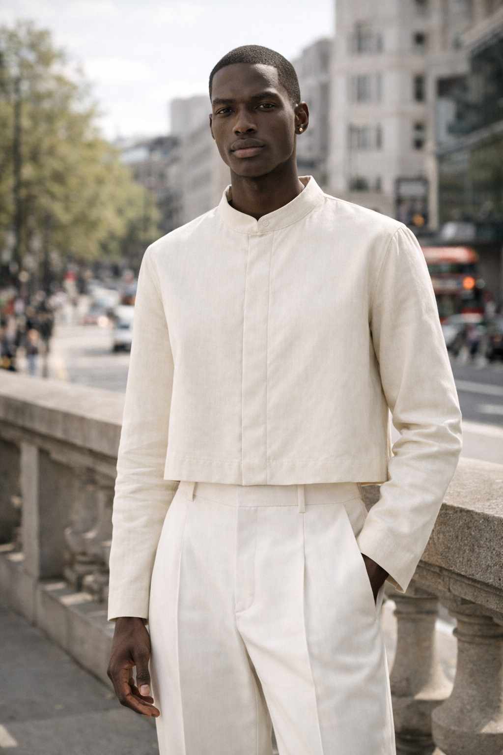 Man wearing a white outfit standing on a city street.